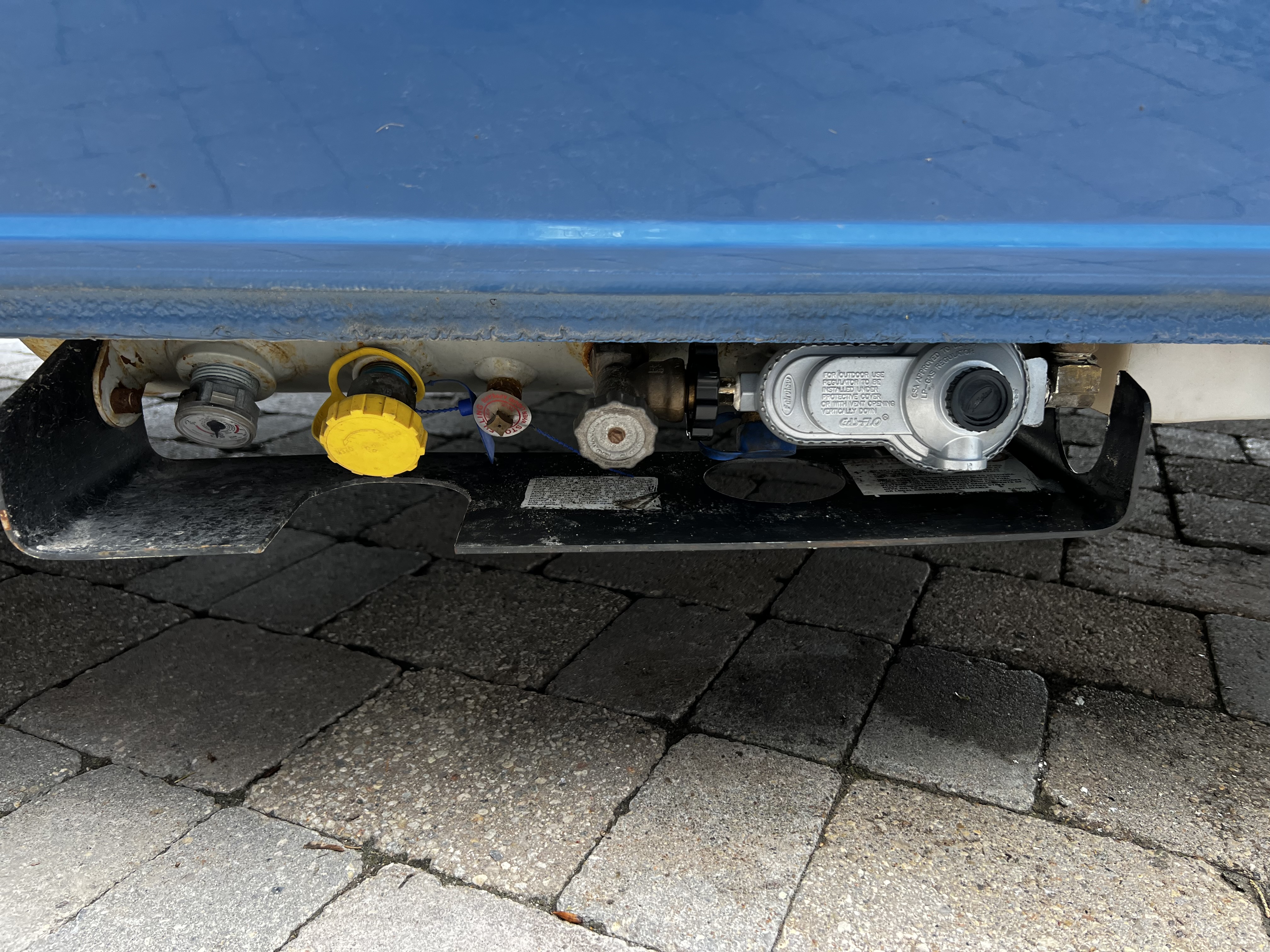 21L Manchester underbody propane tank, which feeds the on-demand hot water heater and the three-burner stove